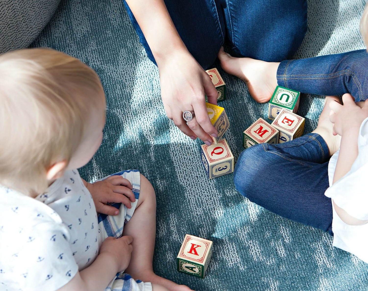 Mutter spielt mit ihren Kindern mit pädagogischen Spielzeugen.